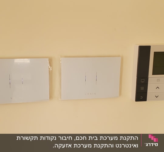שני מתגים לבנים ולוח בקרה טושיבה על קיר
